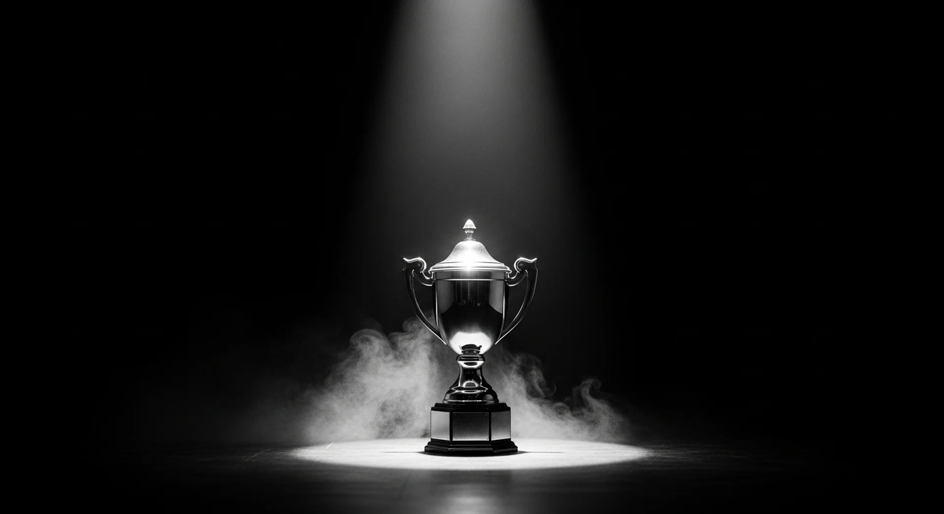 무대 중앙 스포트라이트 조명 아래 빛나는 포커 토너먼트 우승 트로피, 영광의 순간을 포착한 흑백 사진